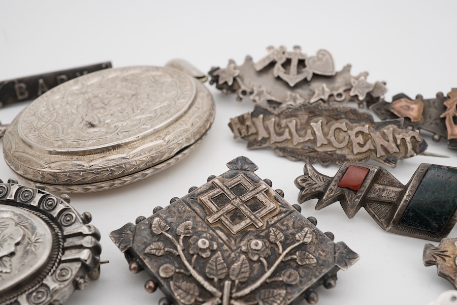 Ten assorted late 19th/early 20th century silver brooches, including three with names, Baby, Millicent and Ellen, together with five other white metal brooches including Scottish hardstones, a coin set stick pin, hardsto
